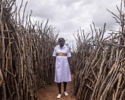 Akol Anna Grace, an assistant nursing officer of Kopoth Health Centre, poses between houses during a home visit in Kopoth, Karamoja region, Uganda, on May 25, 2022. Badru Katumba/AFP via Getty